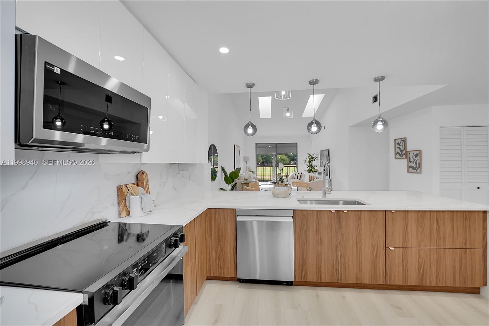 7736 La Mirada Drive Boca Raton, FL 33433 - Photo 16 of 56 a kitchen with kitchen island white cabinets and appliances