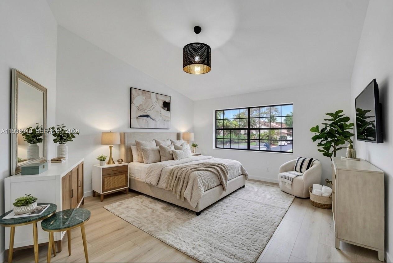 7736 La Mirada Drive Boca Raton, FL 33433 - Photo 29 of 56 a spacious bedroom with a bed a couch and a potted plant