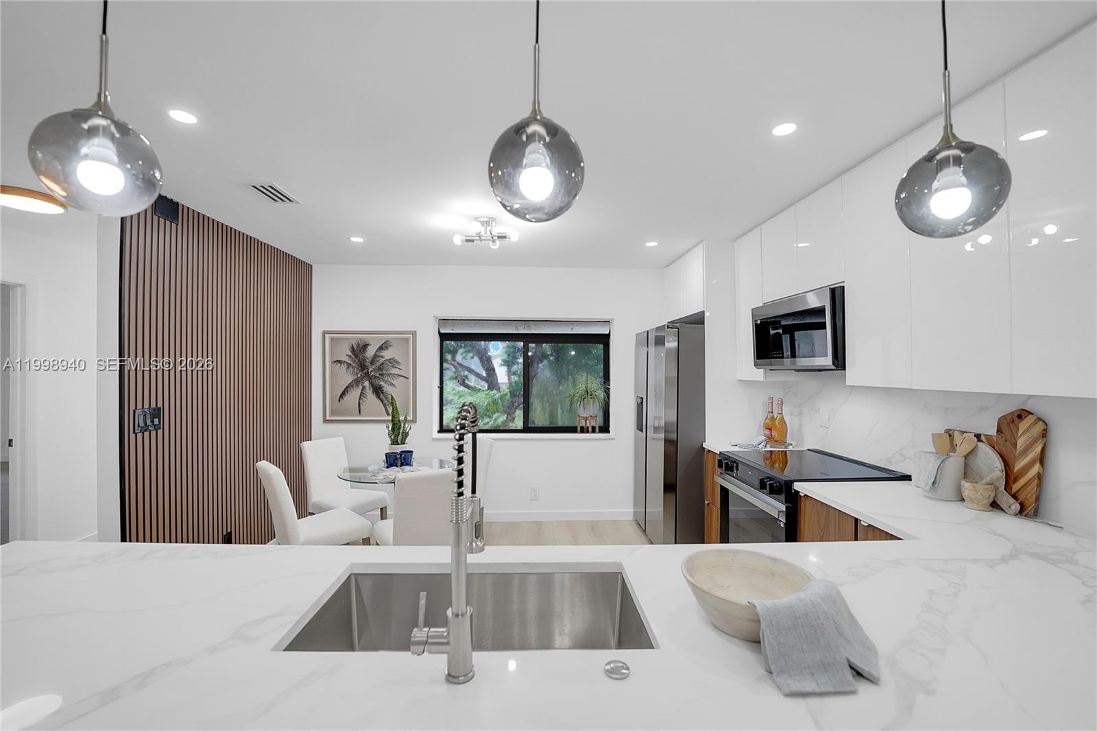 7736 La Mirada Drive Boca Raton, FL 33433 - Photo 3 of 56 a living room with furniture a flat screen tv and kitchen view