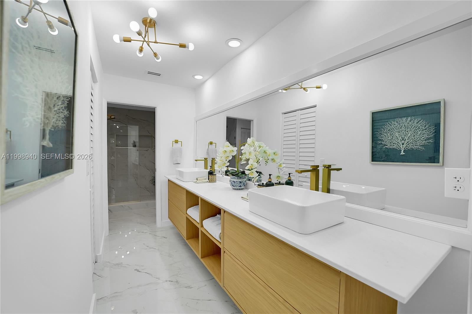 7736 La Mirada Drive Boca Raton, FL 33433 - Photo 31 of 56 a bathroom with a sink a large mirror and a shower