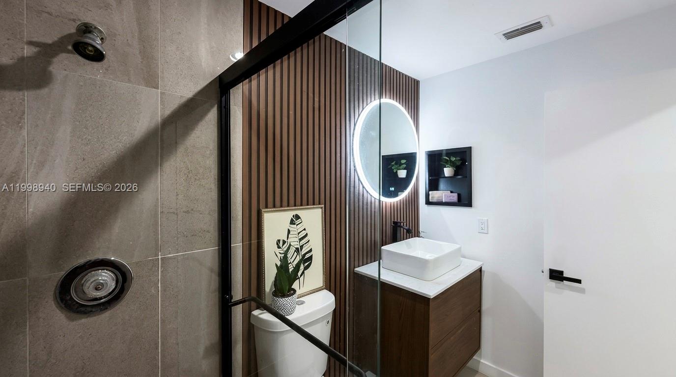 7736 La Mirada Drive Boca Raton, FL 33433 - Photo 37 of 56 a bathroom with a sink a mirror and shower