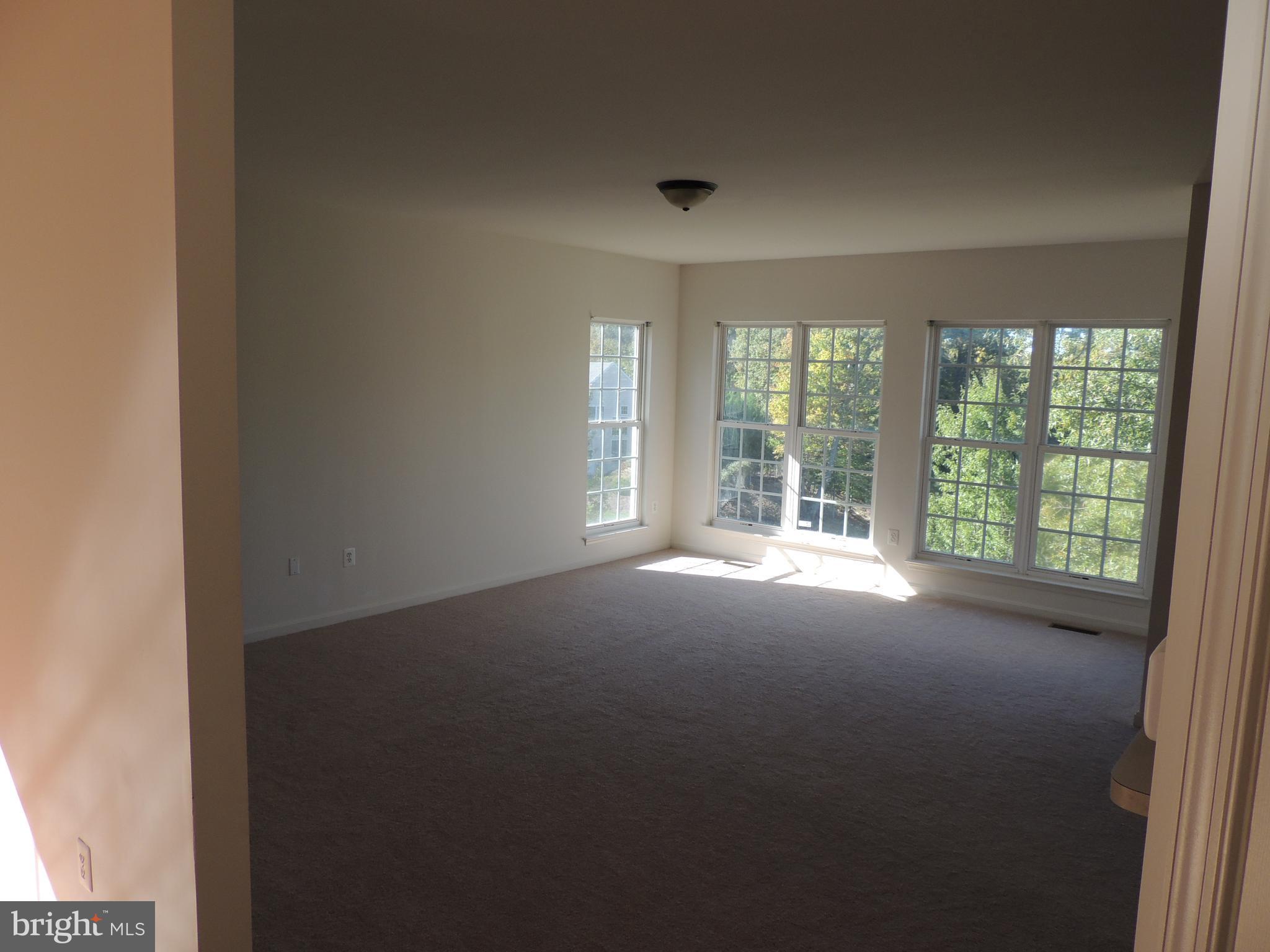 17676 Hampstead Ridge Court Dumfries, VA 22026 - Photo 6 of 22 a view of empty room with wooden floor and fan