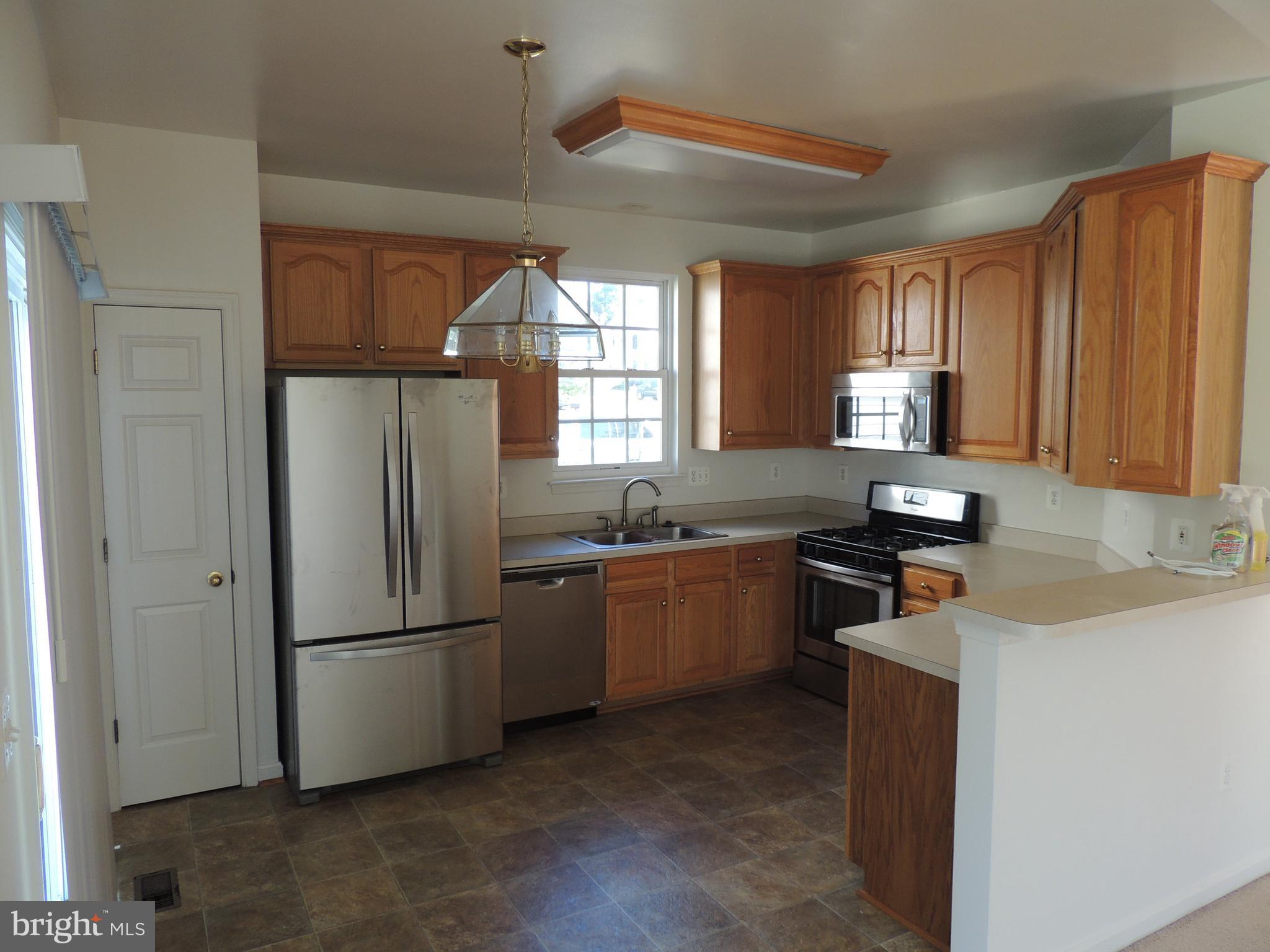 17676 Hampstead Ridge Court Dumfries, VA 22026 - Photo 9 of 22 a kitchen with stainless steel appliances granite countertop a refrigerator a sink a stove a microwave and island