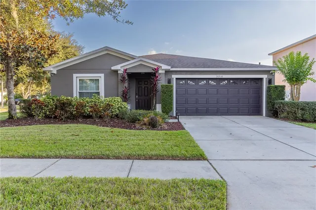 a front view of a house with a yard and garage