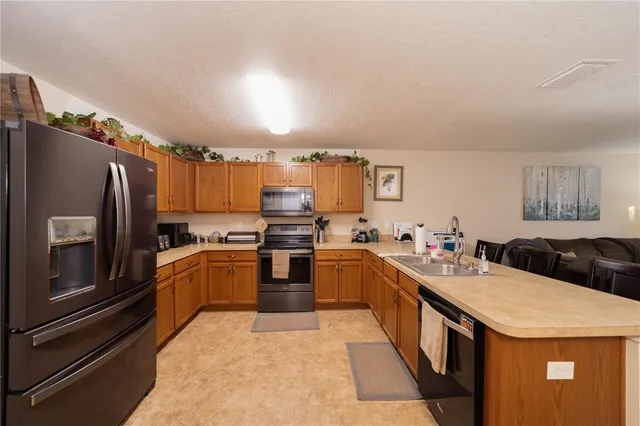a kitchen with granite countertop stainless steel appliances and wooden cabinets