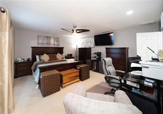 a living room with furniture a flat screen tv and kitchen view