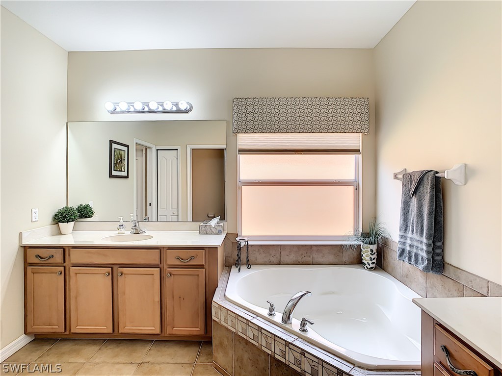 2816 Via Piazza Loop Fort Myers, FL 33905 - Photo 21 of 34 a bathroom with a tub sink and mirror