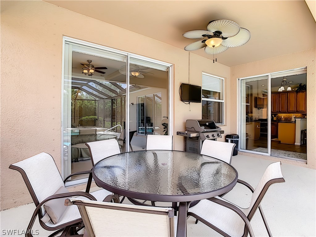 2816 Via Piazza Loop Fort Myers, FL 33905 - Photo 27 of 34 a dining room with wooden floor a chandelier a glass table and chairs