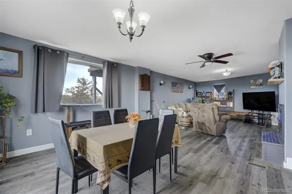 a view of a livingroom with wooden floor and furniture