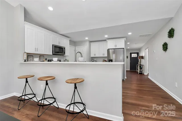 a kitchen with stainless steel appliances kitchen island a refrigerator and a stove top oven