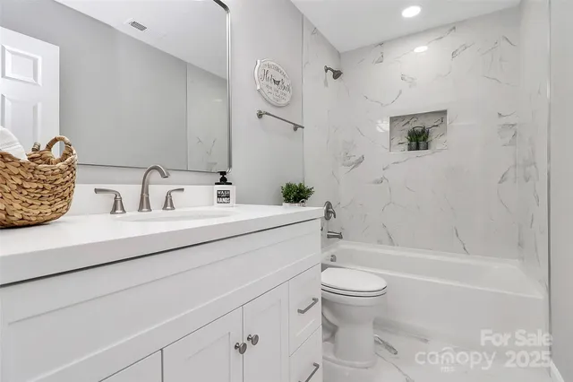 a bathroom with a sink a toilet and a large mirror