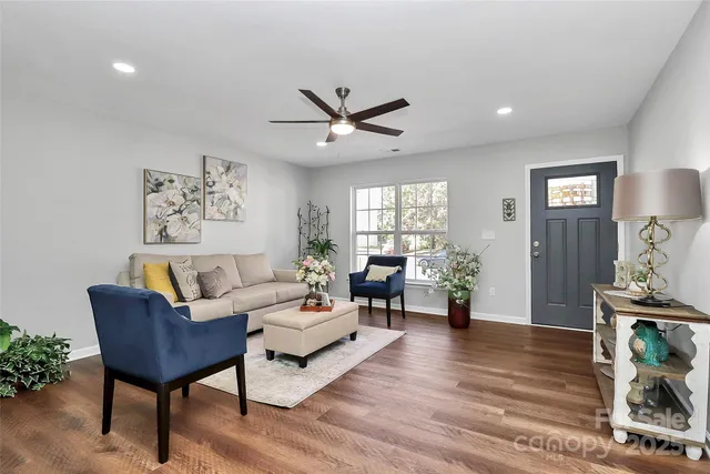a living room with furniture and a wooden floor