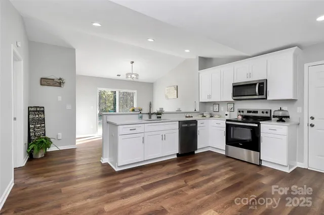 a kitchen with granite countertop a sink cabinets and stainless steel appliances