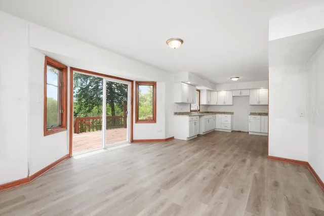 a view of a kitchen with wooden floor and windows
