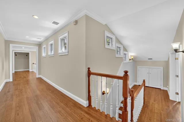 a view of a hallway with wooden floor and stairs