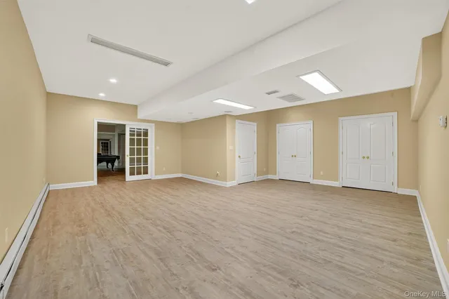 a view of an empty room with wooden floor and closet