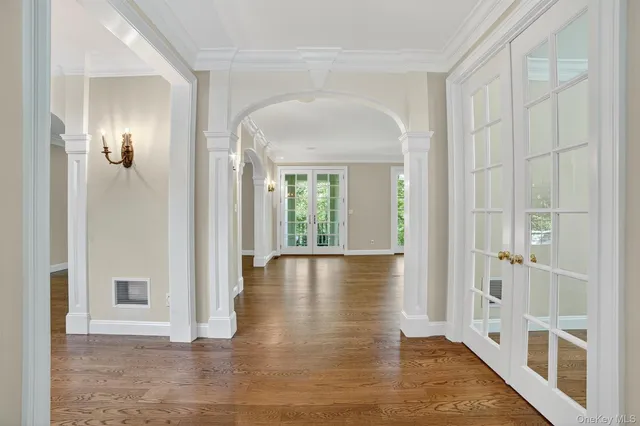 a view of a hallway with wooden floor and glass door