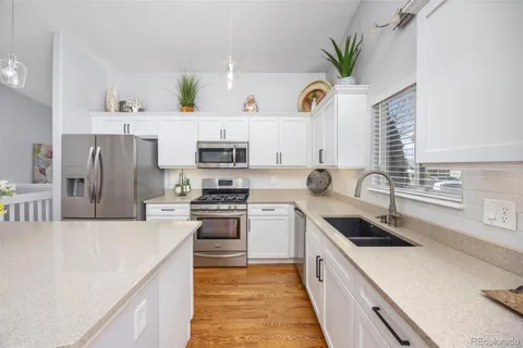 a kitchen with stainless steel appliances a white refrigerator a sink a stove and cabinets