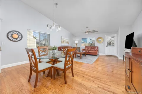 a view of a dining room with furniture a rug and wooden floor