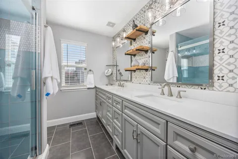 a bathroom with a granite countertop sink a mirror and a shower