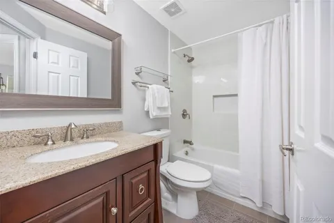 a bathroom with a granite countertop sink toilet a shower and a mirror
