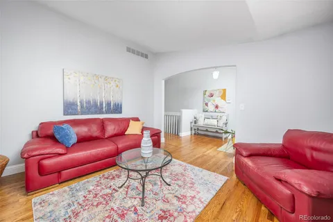 a living room with furniture and a wooden floor