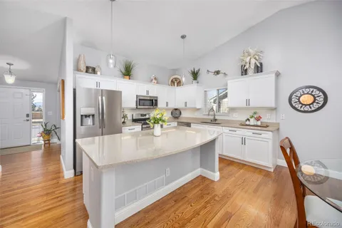 a kitchen with stainless steel appliances granite countertop a sink a stove and refrigerator
