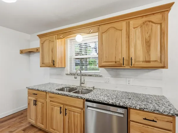 a kitchen with granite countertop cabinets sink and window