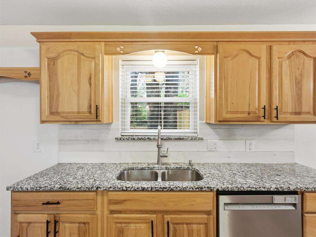 209 Valley View Court Azle, TX 76020 - Photo 12 of 39 Kitchen featuring stainless steel dishwasher, light stone countertops, and light wood finish cabinets
