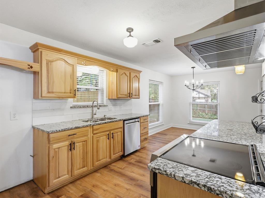 209 Valley View Court Azle, TX 76020 - Photo 15 of 39 Kitchen with extractor fan, light stone counters, black electric stovetop, and light wood finished floors
