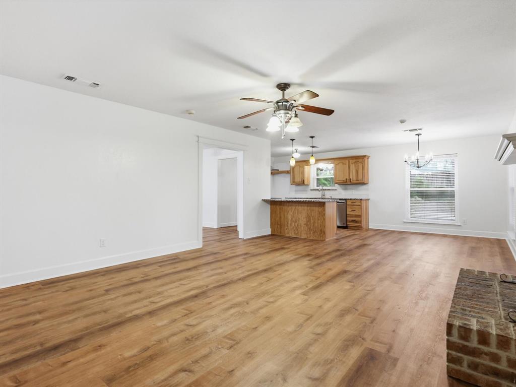 209 Valley View Court Azle, TX 76020 - Photo 18 of 39 Unfurnished living room featuring a chandelier, ceiling fan, and light wood-style floors