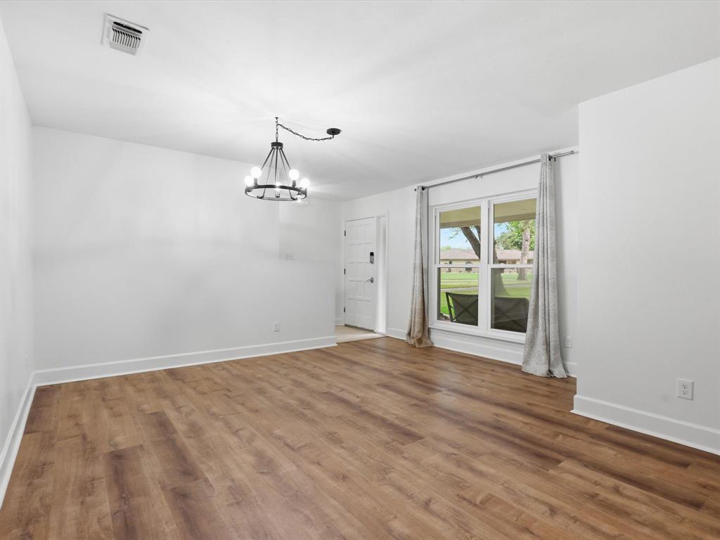 209 Valley View Court Azle, TX 76020 - Photo 23 of 39 Unfurnished dining area featuring wood finished floors and a chandelier
