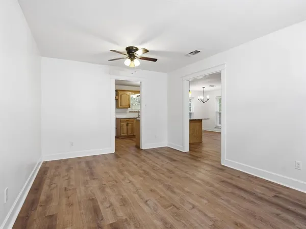 a view of empty room with wooden floor and ceiling fan