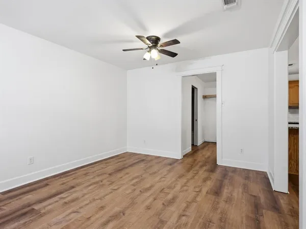 a view of empty room with wooden floor