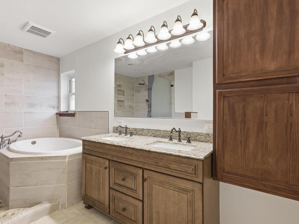 209 Valley View Court Azle, TX 76020 - Photo 30 of 39 Full bathroom featuring double vanity, a garden tub, light tile patterned floors, and tiled shower