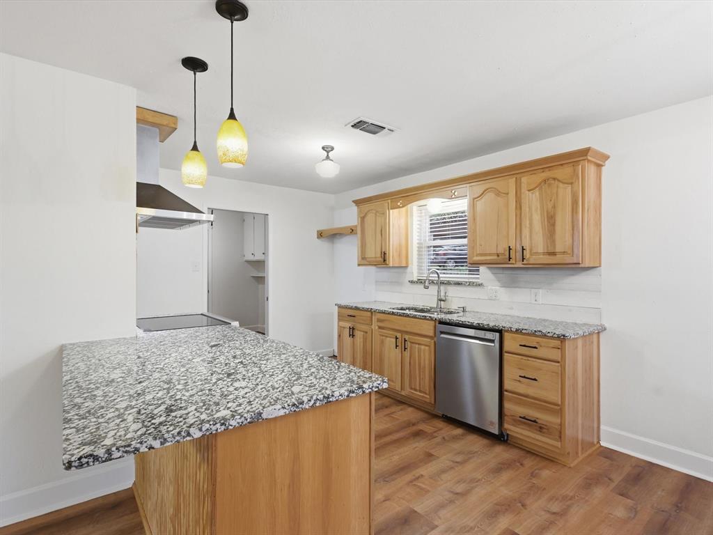 209 Valley View Court Azle, TX 76020 - Photo 8 of 39 Kitchen with light stone countertops, a peninsula, light wood-style floors, and stainless steel dishwasher