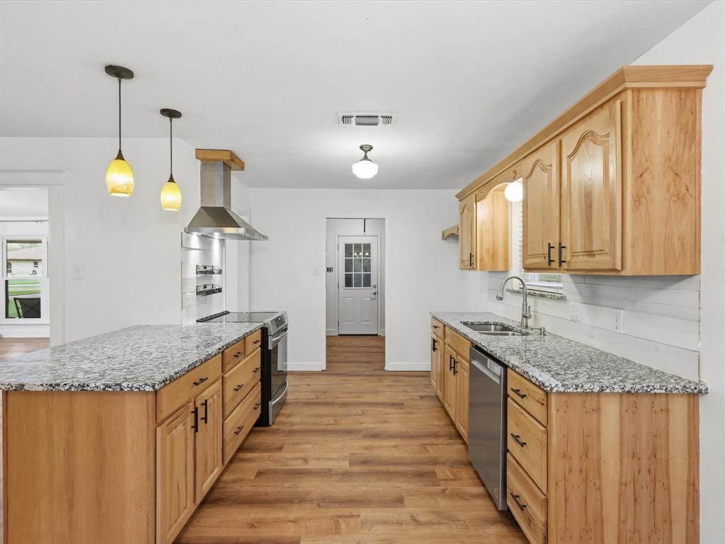 209 Valley View Court Azle, TX 76020 - Photo 9 of 39 Kitchen with light stone counters, stainless steel appliances, light wood-style floors, and light wood finish cabinets