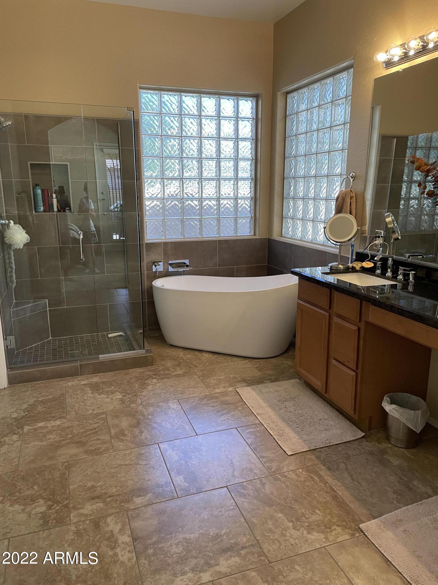 4604 West Moss Springs Road Phoenix, AZ 85086 - Photo 13 of 15 a spacious bathroom with a tub sink and mirror