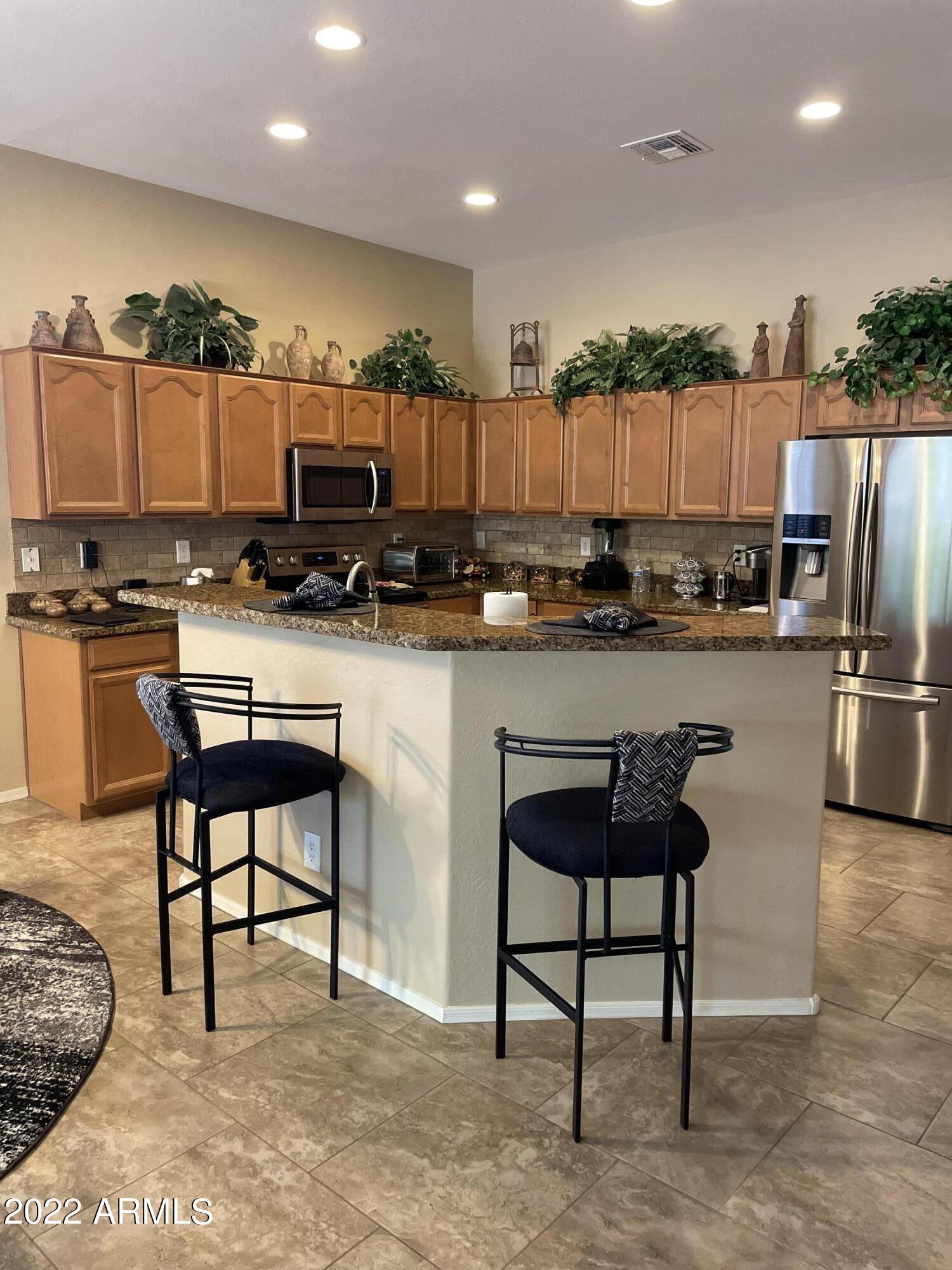 4604 West Moss Springs Road Phoenix, AZ 85086 - Photo 5 of 15 a kitchen with a table chairs refrigerator and microwave