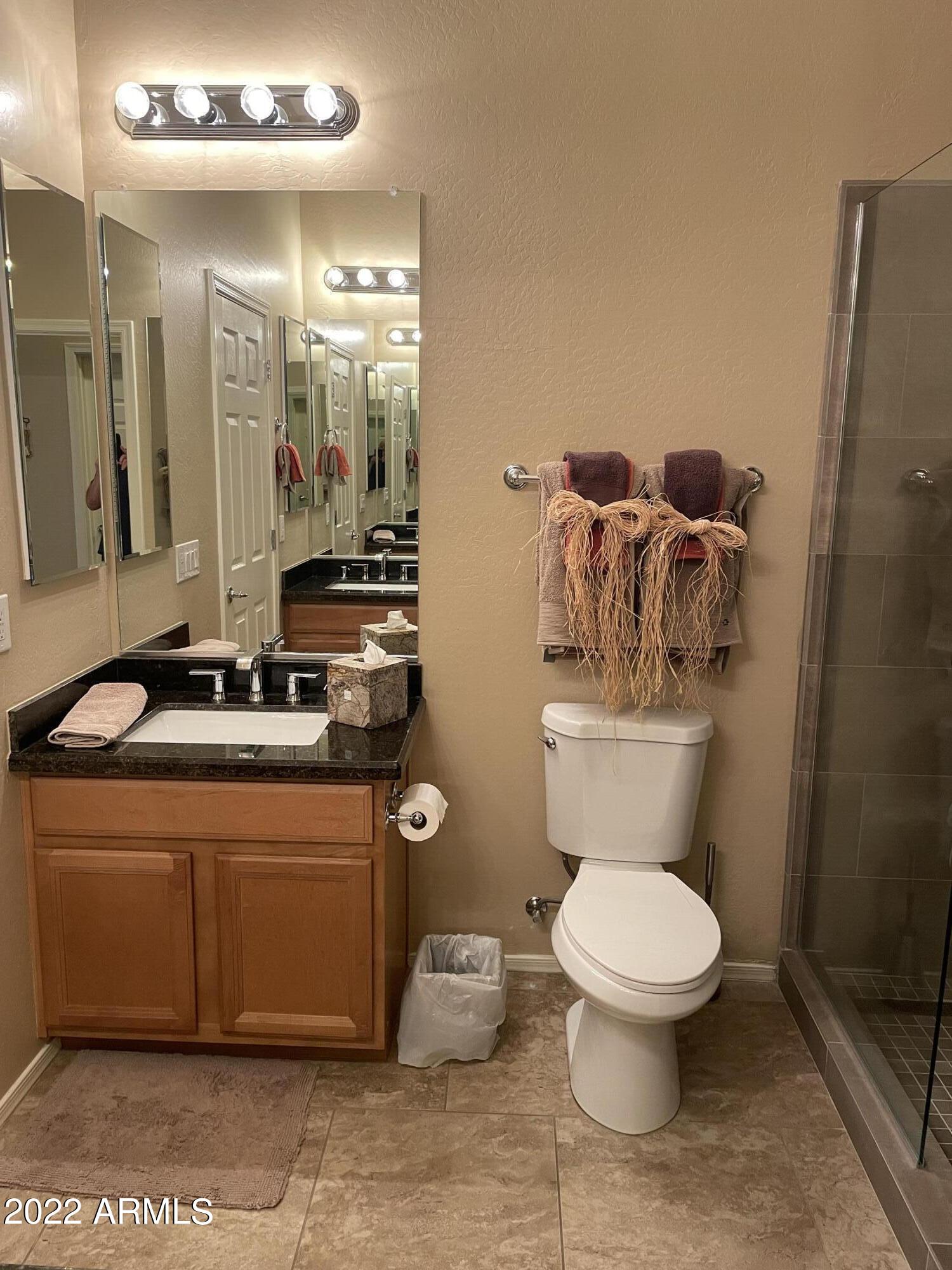 4604 West Moss Springs Road Phoenix, AZ 85086 - Photo 8 of 15 a bathroom with a granite countertop toilet a sink and a mirror