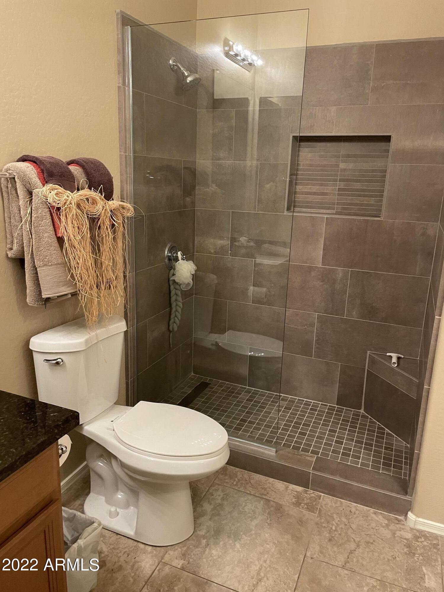 4604 West Moss Springs Road Phoenix, AZ 85086 - Photo 10 of 15 a white toilet sitting next to a bath tub and shower