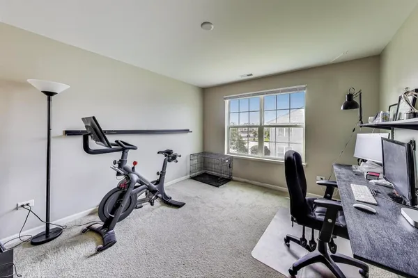 a view of a workspace with furniture and a window