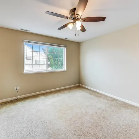 an empty room with a window and a fan