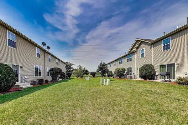 a front view of house with a garden and trees