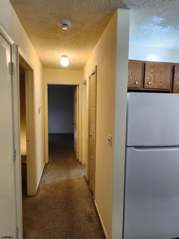 a view of a hallway with wooden shelves