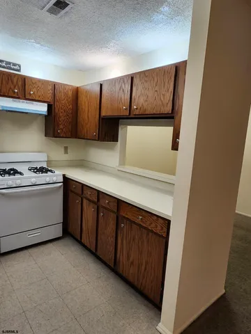 a kitchen with wooden cabinets and white appliances