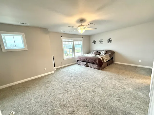 a spacious bedroom with a bed and window