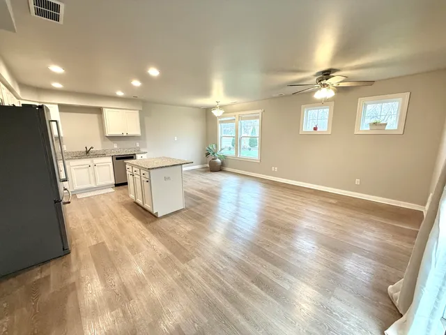 a large kitchen with a lot of counter space and wooden floor