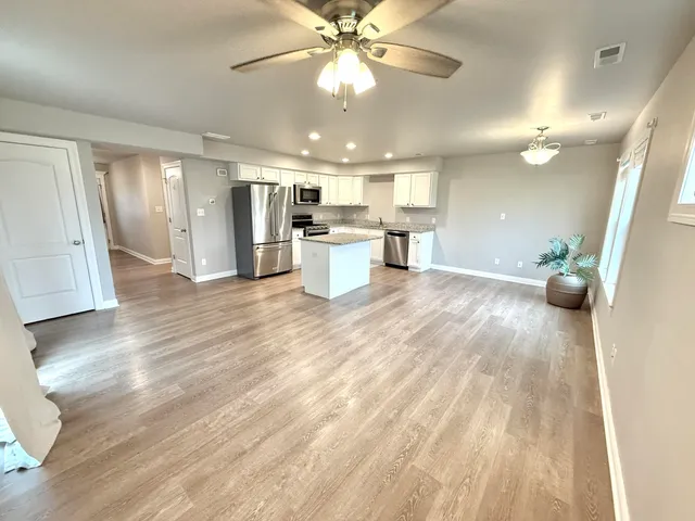 a view of a kitchen with kitchen island a counter top space appliances and cabinets