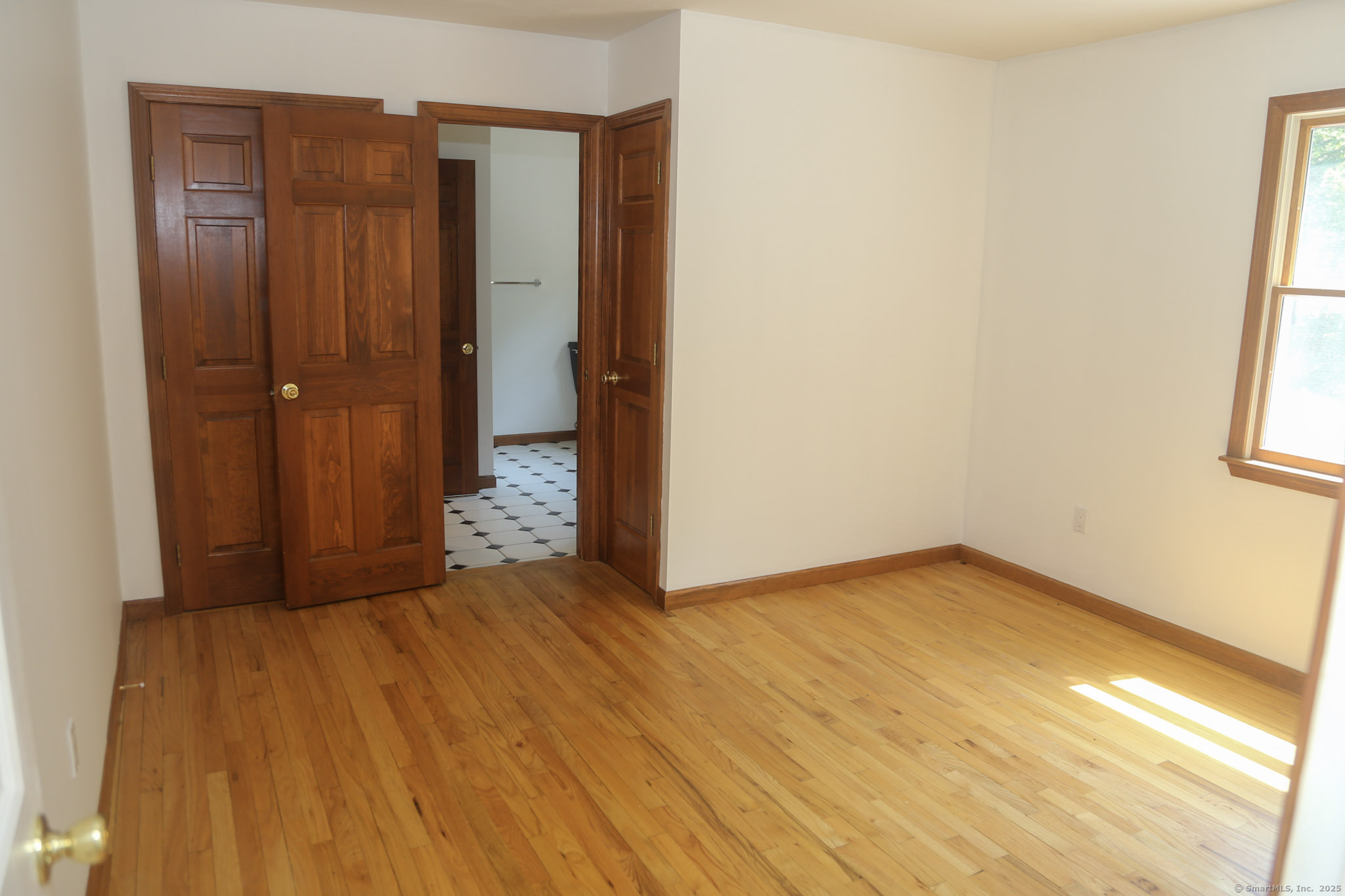 189 Crane Hollow Road Bethlehem, CT 06751 - Photo 13 of 40 a view of an empty room with wooden floor and a window